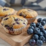 Freshly baked buckwheat blueberry banana muffins served with a handful of blueberries.